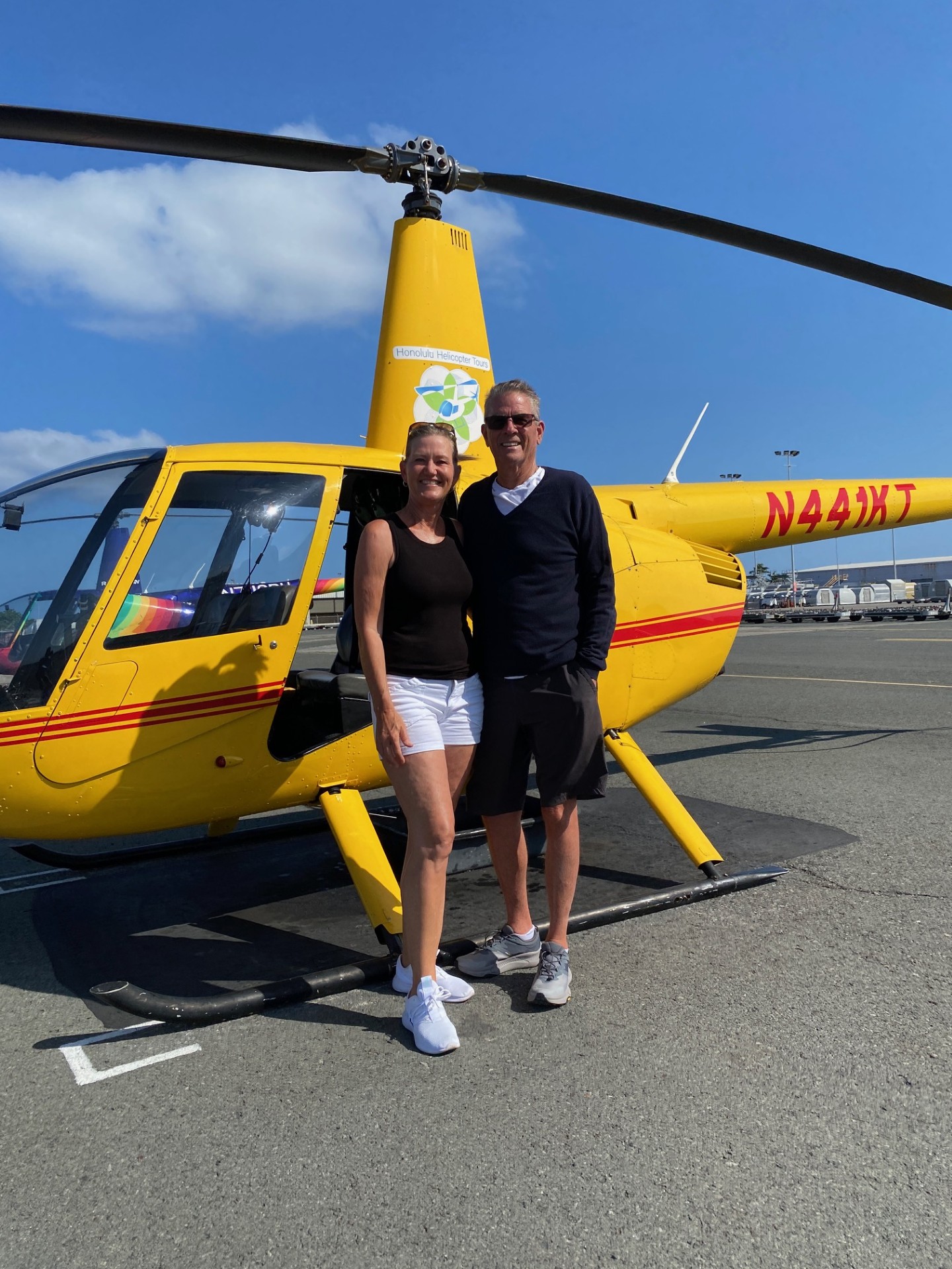 Jim and Diana Robeson infront of a helicopter during their vaction in Hawaii