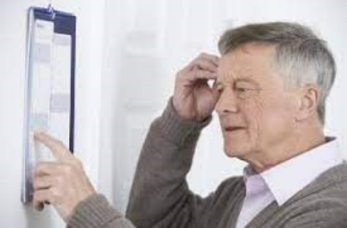 Elderly man looking at a chart on the wall